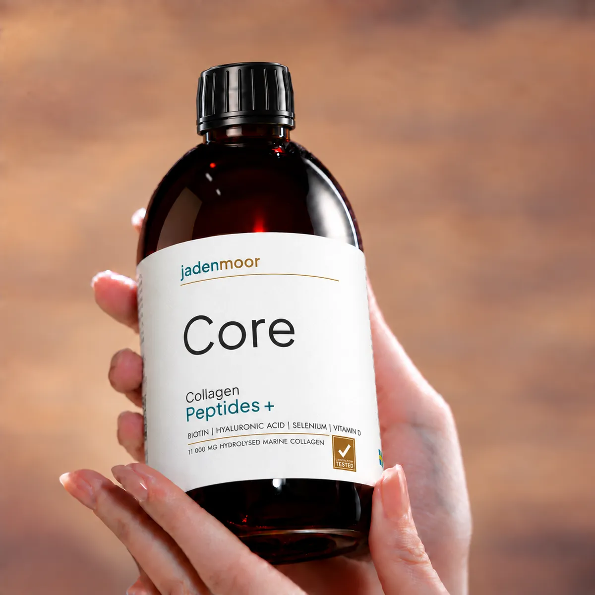 A hand holding a pack of Jadenmoor Core liquid marine collagen